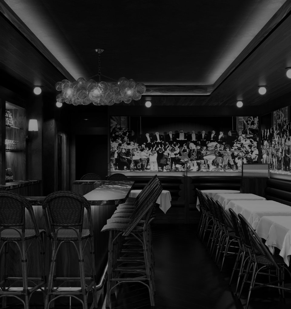 A black and white photo the restaurant with tables and chairs, a chandelier on the ceiling, and vintage murals on the wall.